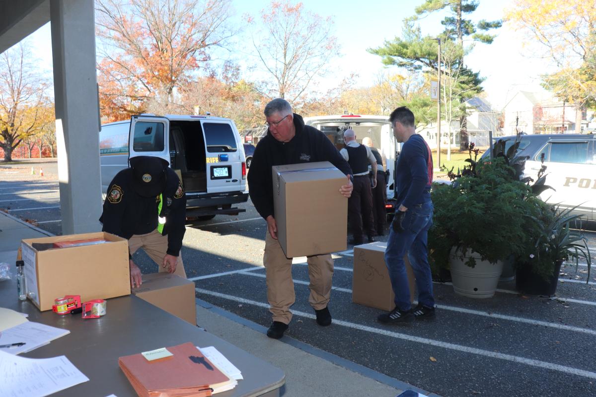 Law enforcement from local, county and federal levels unload boxes of drugs turned in for disposal Saturday.